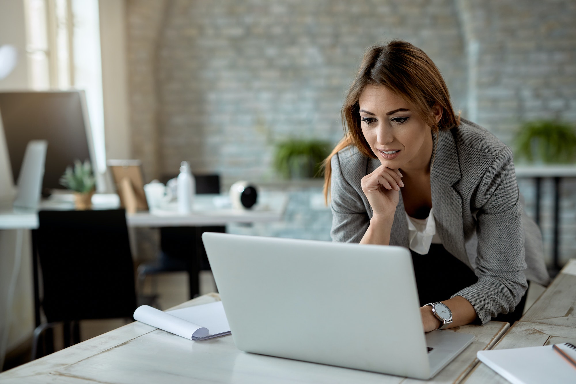 Female entrepreneur reading an e-mail on laptop in the office.